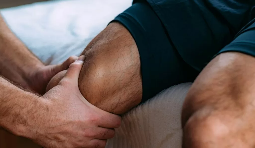 man getting a sports massage for his upper thigh and knee
